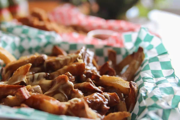 Fast food take out of Canadian poutine with cheese melting over French fries with beef gravy in a basket ready to eat