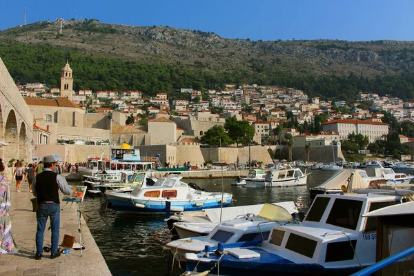 Férfi festékek táj hajók és házak Dubrovnik, Horvátország — Stock Fotó