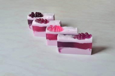 Frenk üzümü ile süslenmiş dört parça güzel el yapımı üzümü sabunu.