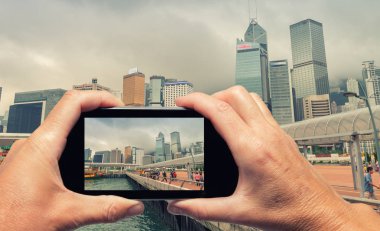 erkek ve kadın el smartphone ile Hong kong manzarası yakalama.