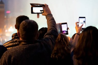 Arkadan görünüşü insanlar akıllı telefonlar kayıt ışık gösterisi ile geceleri.