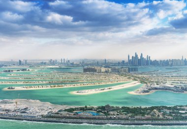 Palm Jumeirah Adası ve Dubai siluetinin havadan görünümü.