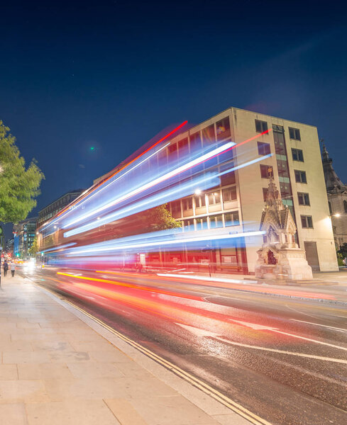 Double Decker bus light trails in London streets.