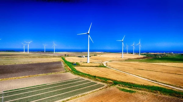 夏の牧草地と工業用風車のパノラマ ビュー — ストック写真