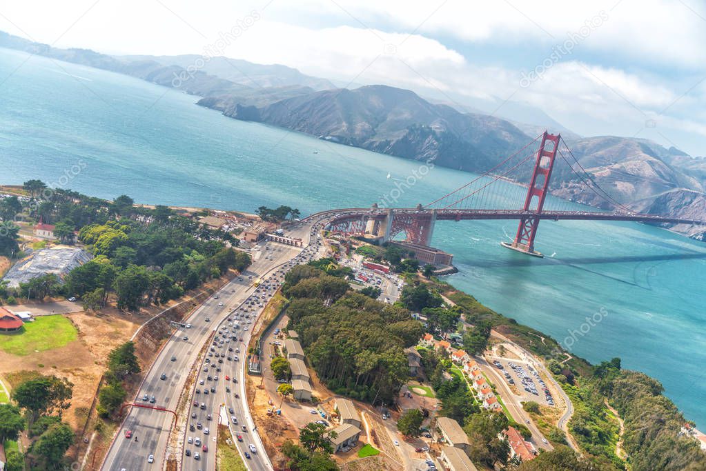 Aerial overhead view of San Francisco Golden Gate Bridge and city traffic from helicopter.