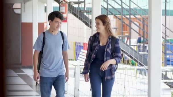 Pareja Adolescentes Caminando Hablando Pasillo Escuela — Vídeos de Stock