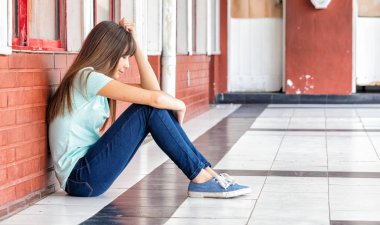 Asya genç okul salonunda oturmuş zorbalık için endişeli.