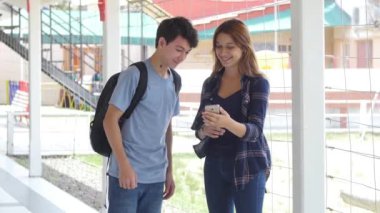 Birkaç genç smartphone okul koridorunda söz