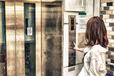 Kadın arayan Asansör Tokyo Metro İstasyonu.