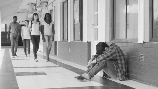 学校の廊下で歩くと 床に座っている男の子をいじめはティーンエイ ジャーのグループ — ストック動画