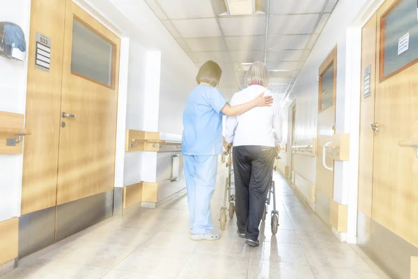 空から来る光線病院廊下で歩行で老婆を助けるアジア医師 — ストック写真