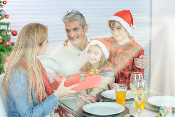Kaukasisk Familie Fire Ved Julebordet Med Gaver Solstråler Fra Utsiden – stockfoto