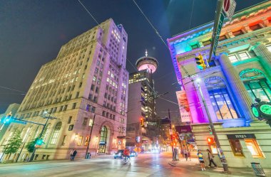 VANCOUVER, CANADA - AUGUST 9, 2017: City streets and buildings at night. Vancouver attracts 15 million tourists annually. clipart