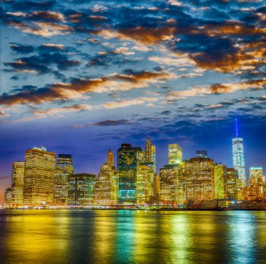 Manhattan ışıkları gün batımında, nehir yansımaları.