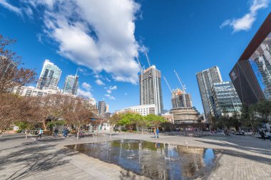 Sydney, Avustralya - 19 Ağustos 2018: Şehir gökdelenler güneşli bir günde güzel bir park. Sydney her yıl 15 milyon turist çeken.