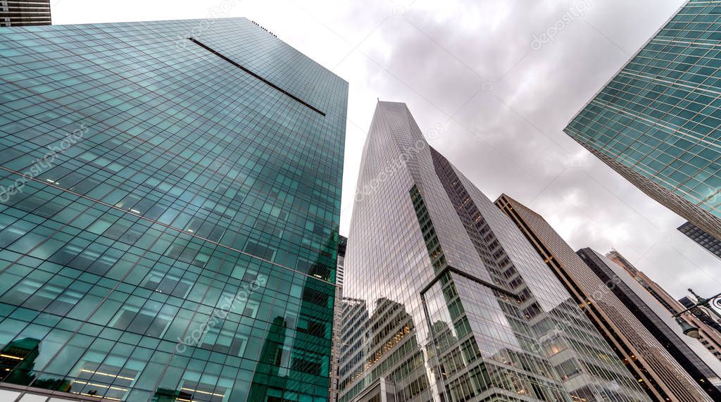 Modern skyscrapers of New York as seen from the street against a overcast sky.