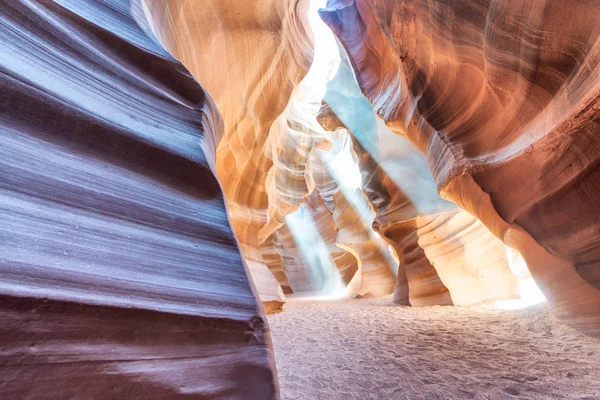 Beam of sand is flowing off the rocks in the interior of the narrow walls of the winding Antelope Canyon, Arizona.