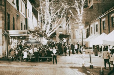 Sydney - 17 Ağustos 2018: Gece görünümü The Rocks bölgesinin. Bu bölgenin genç insanlar için bir buluşma noktasıdır.