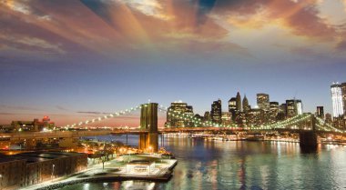 Brooklyn Köprüsü NYC üzerinde günbatımı renkleri çarpıcı, Manhattan Köprüsü'nden görüntülemek