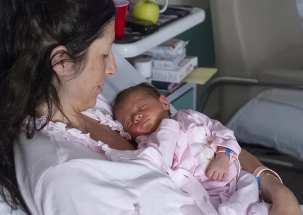 快乐的母亲在医院用爱心抱着刚出生的孩子 — 图库照片