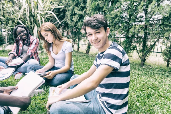 一群多民族的青少年在草地上上课 — 图库照片