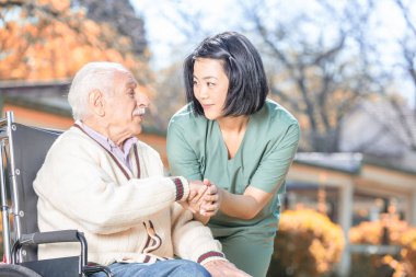 Hemşire Yaşlı bir adam tekerlekli sandalyede teselli.