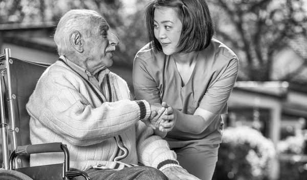 Verpleegkundige Een Oudere Man Een Rolstoel Troosten — Stockfoto