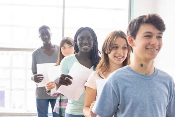 Grupo Chicos Sonrientes Alineados Entregando Tarea Profesor —  Fotos de Stock