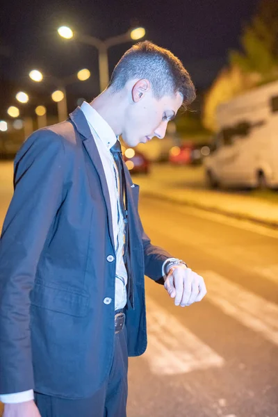 Takım Elbiseli Genç Bir Adam Gece Görüşmesi Için Saatine Bakıyor — Stok fotoğraf