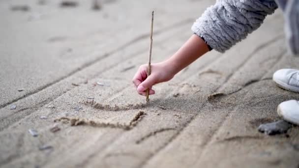 Mladá dívka psaní láska na pláži. Koncept mír a přátelství