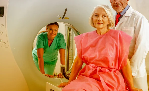 60岁的妇女准备接受 Mri 并得到两位让人放心的医生的协助 — 图库照片
