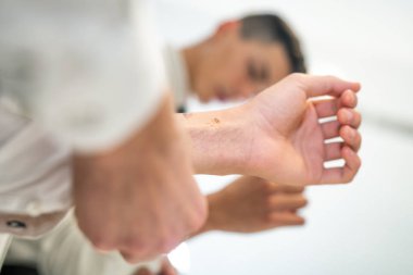 Genç adam Yöneticisi işe gitmeden gömlek kelepçeleri takılır.