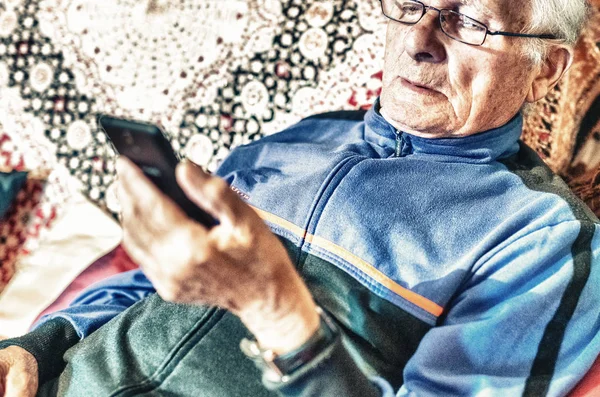 Oudere Man Met Bril Kijken Naar Mobiele Telefoon Thuis — Stockfoto