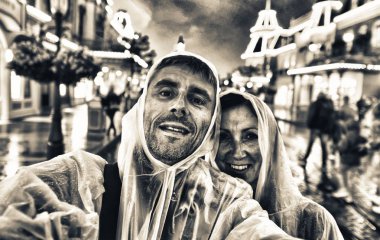 Turist ışıklı sokak yağmurlu bir gecede zevk 40s copule .