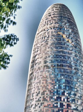 BARCELONA - MAY 14, 2018: Agbar Tower surrounded by trees. It is a major attraction in the city. clipart
