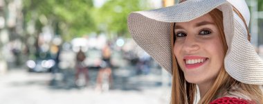 Hasır şapkalı mutlu kız gülen şehir.