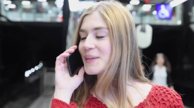 Şehir caddesinde telefonla konuşan genç ve güzel bir kadının görüntüleri. 