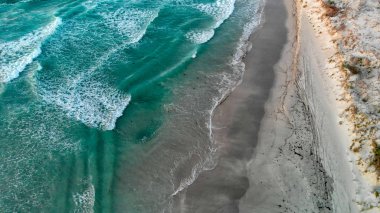 Dalgalar kumsalda, ek yükü havadan görünümü.