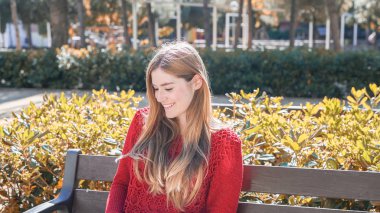 Genç kız bir bankta açık oturma.