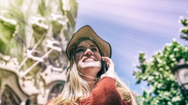 Mutlu genç kadın ile hasır şapka şehir binaları için arıyorsunuz.