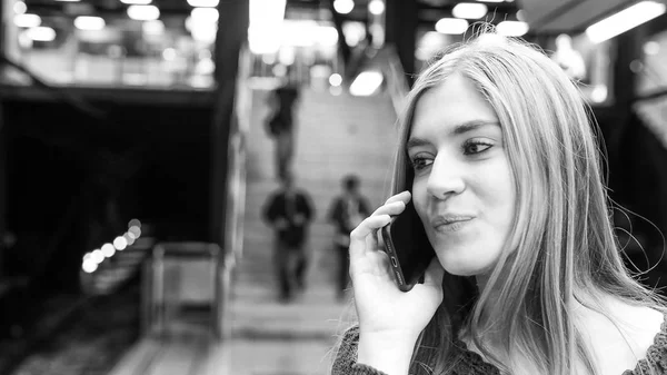 在地铁站里对着电话说话的妇女 — 图库照片