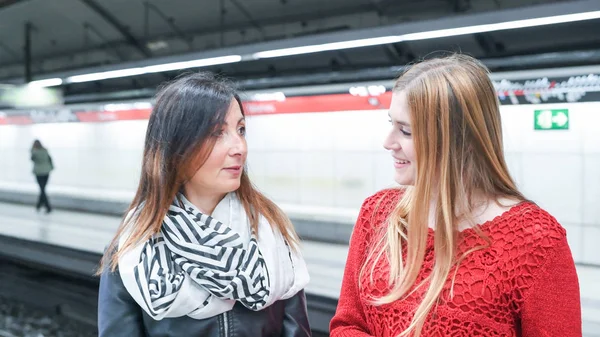 Пара подруг разговаривают на станции метро — стоковое фото