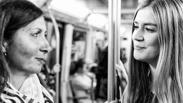 Пара подруг счастливы, разговаривая в поезде метро — стоковое фото