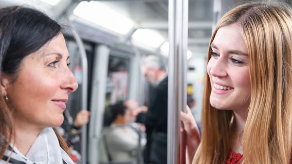 Para przyjaciół kobiet, szczęśliwy, rozmowy w pociągu metra — Zdjęcie stockowe