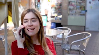 Şehir caddesinde telefonla konuşan genç ve güzel bir kadının görüntüleri. 