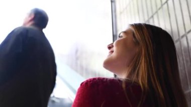 Yürüyen merdivendeki genç ve güzel bir kadının parmak kaldırdığı görüntüler.