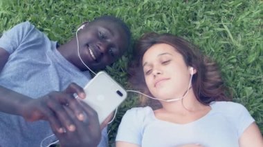 Lisede çim üzerinde müzik dinleyen öğrencilerin görüntüleri.