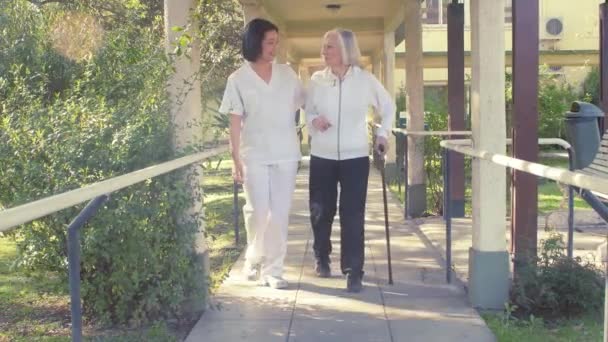 Beeldmateriaal Van Verpleegster Wandelen Met Oudere Vrouw Bejaardentehuis — Stockvideo