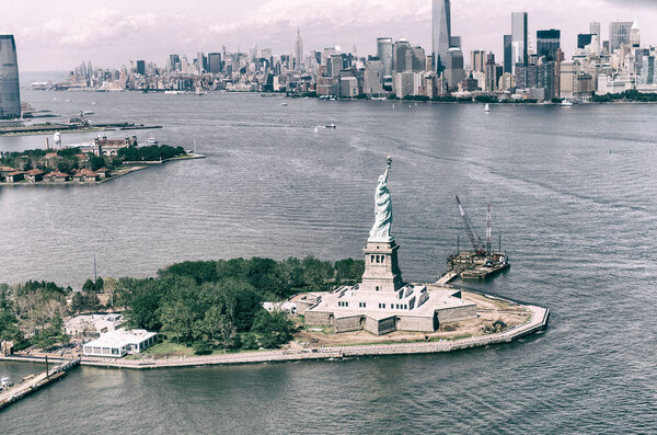 Helicopter view of Statue of Liberty with Lower Manhattan in the background.