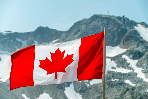 Beautiful Canadian Flag waving for the strong wind, tall mountai Royalty Free Stock Photos